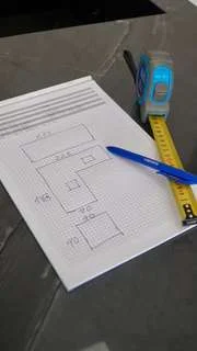 Croquis de una cocina con medidas, un metro y un bolígrafo