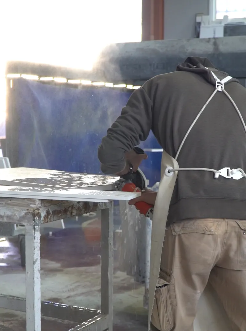 Operario trabajando una pieza de piedra en el taller